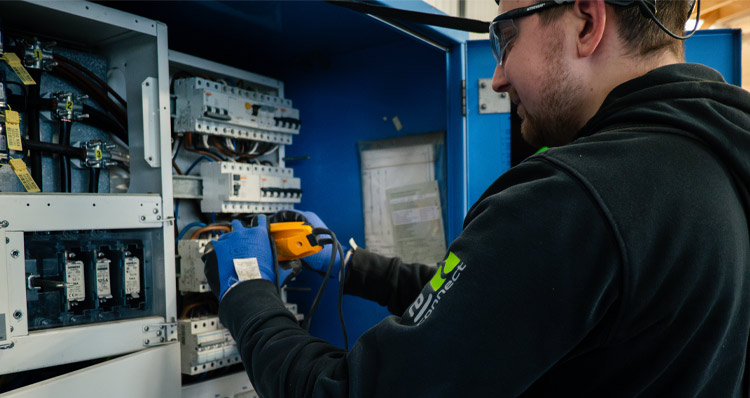 En man arbetar i ett elskåp